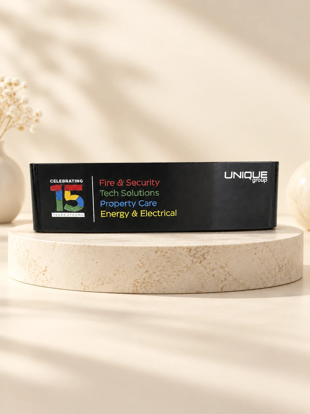 Black Unique Group putter celebrating 15 years, shown on a stone plinth