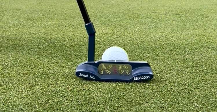 Navy Bertie Boucher putter on the green behind a golf ball, serial BB332001