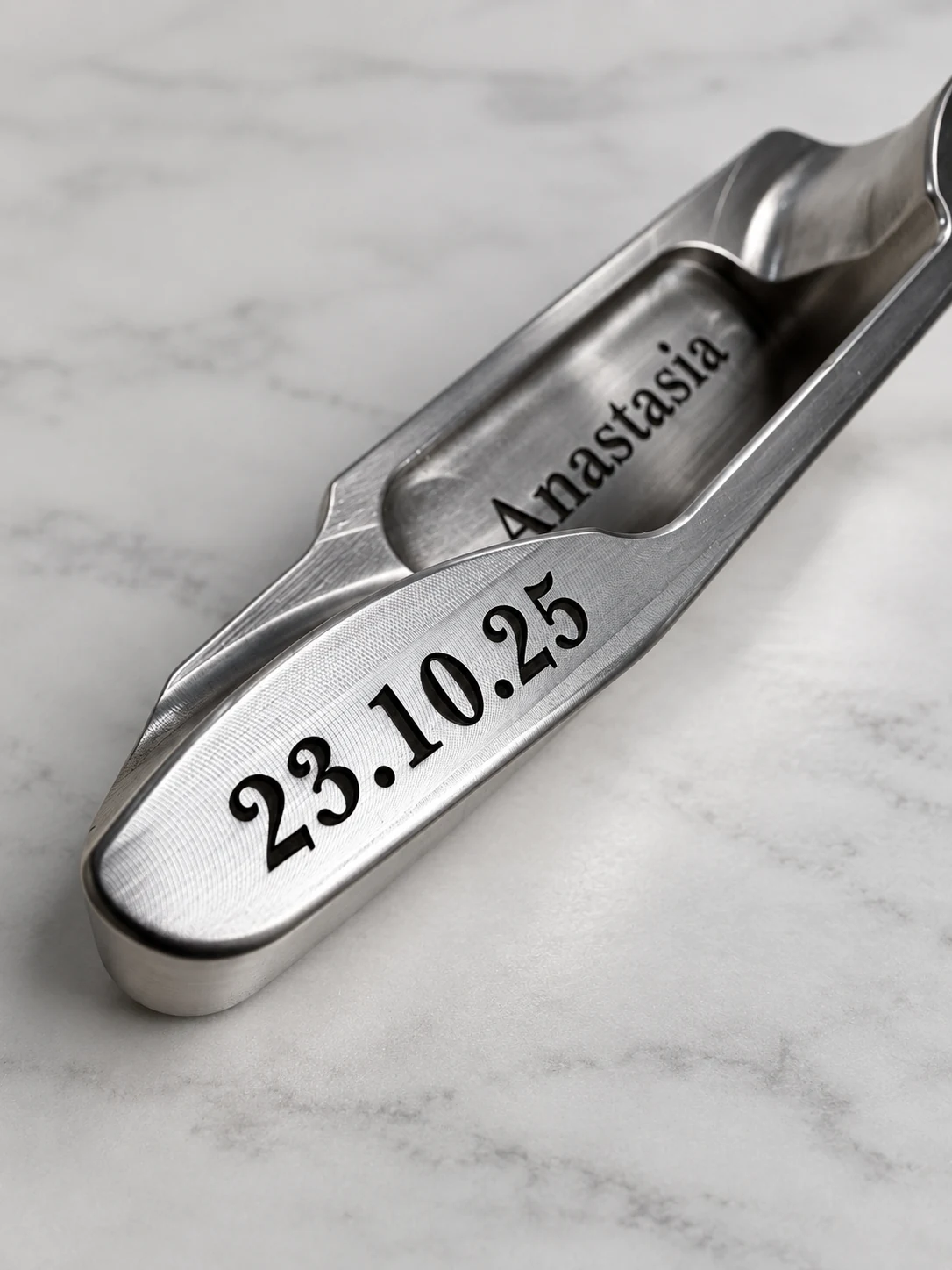 Silver putter engraved Anastasia and 23.10.25 photographed on marble