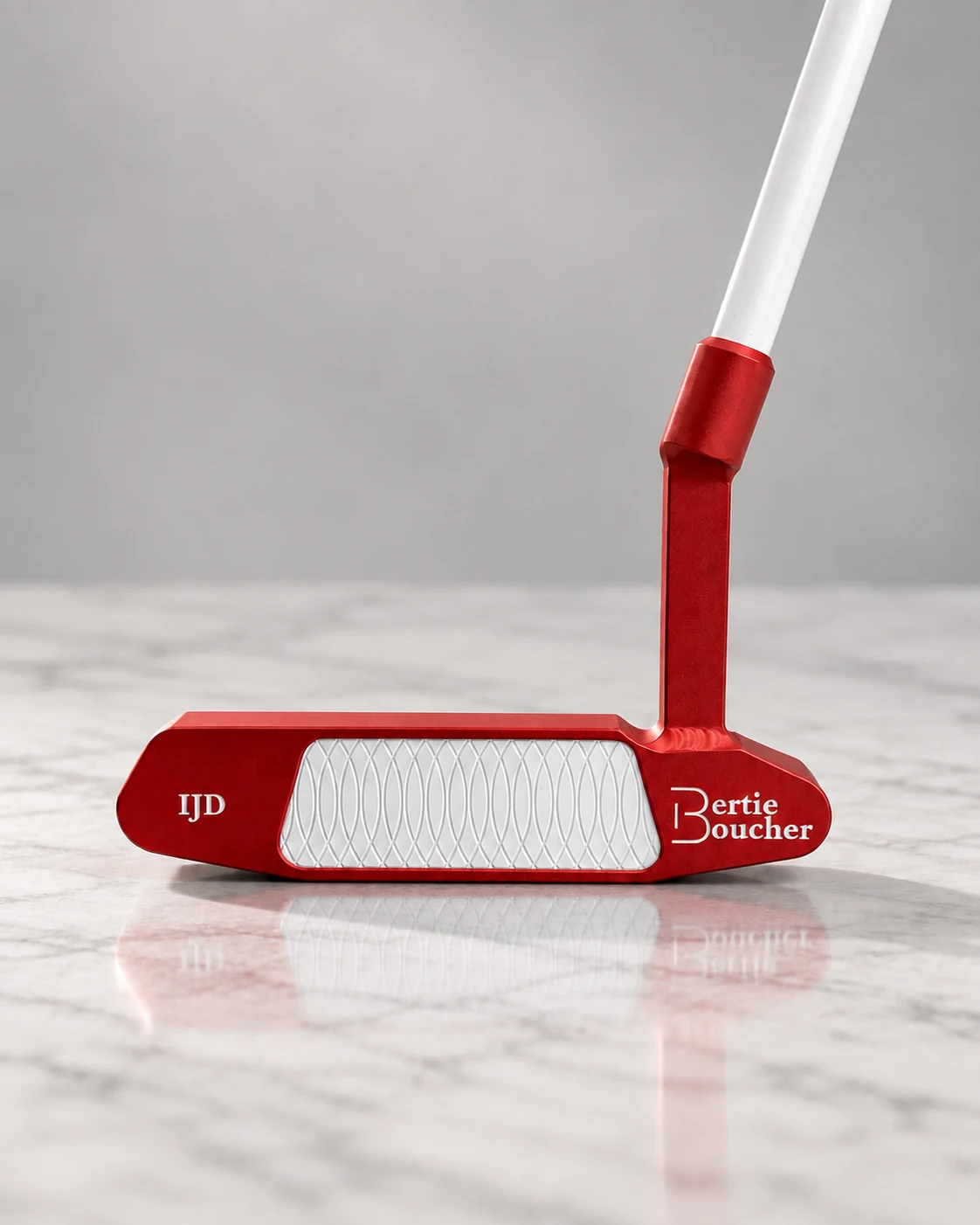 Red putter engraved IJD with white insert and white shaft on marble