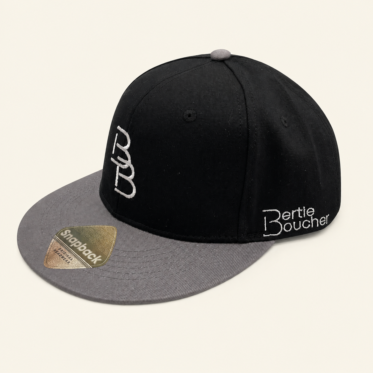 Bertie Boucher black snapback cap with grey peak and white embroidery