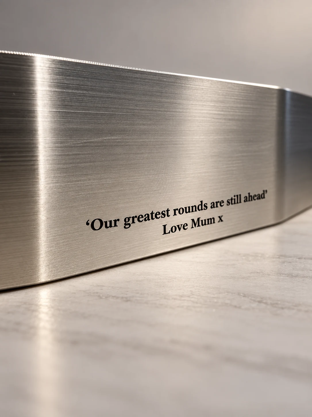 Close-up of a silver putter engraved Our greatest rounds are still ahead, Love Mum x