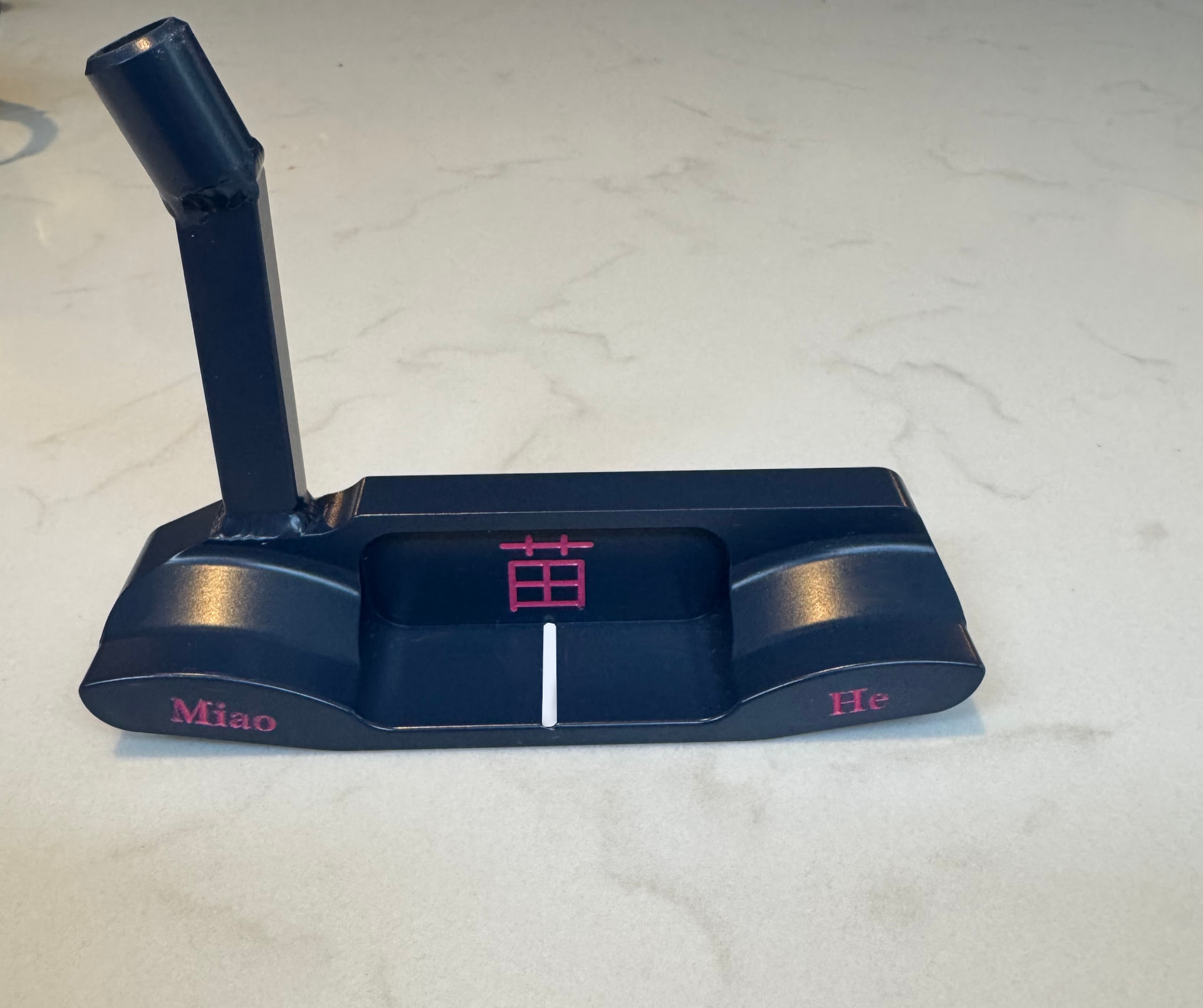 Black bespoke putter with pink personal engraving shown from the front