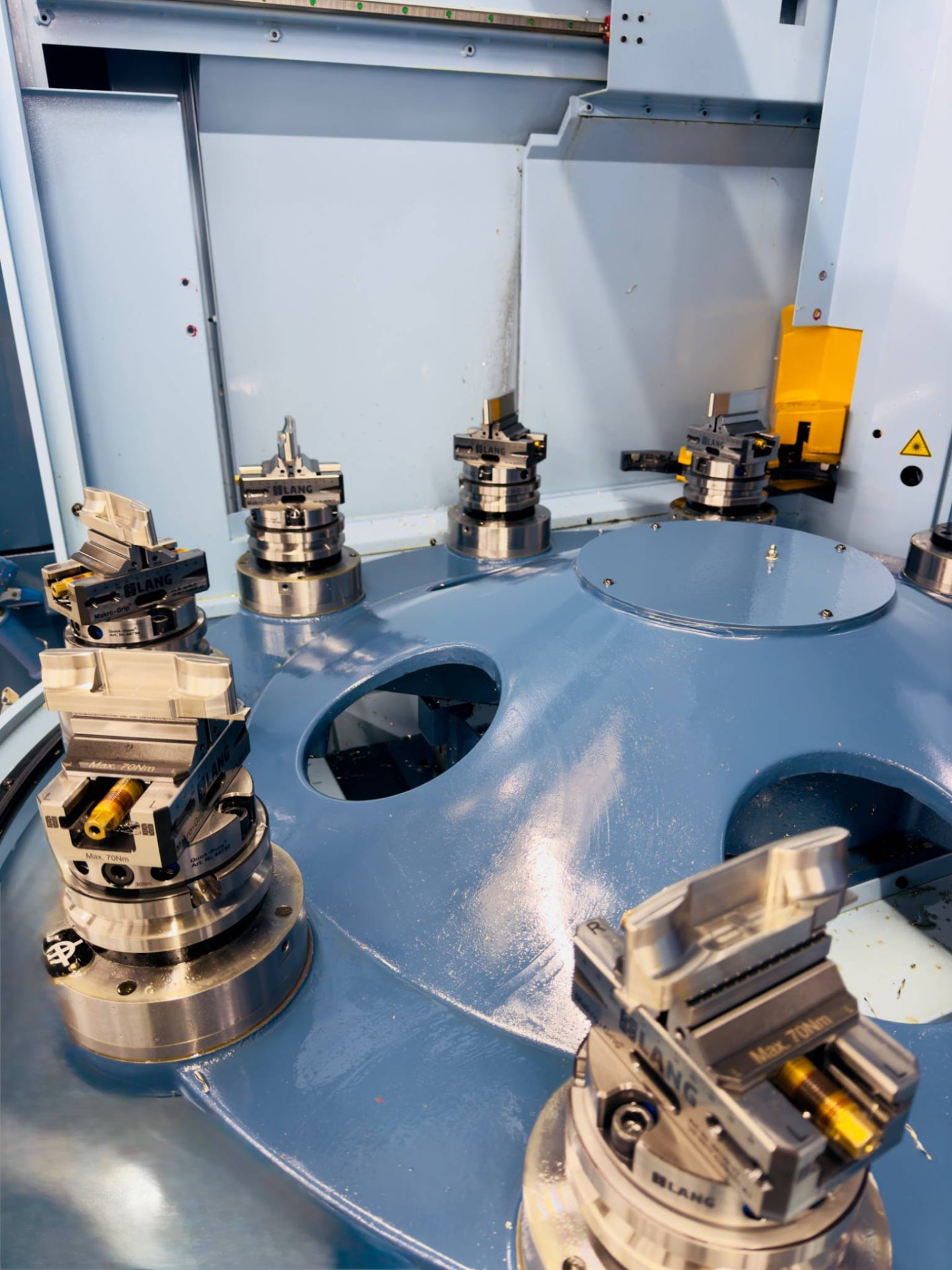 Five-axis CNC machine carousel fitted with Lang workholding vices