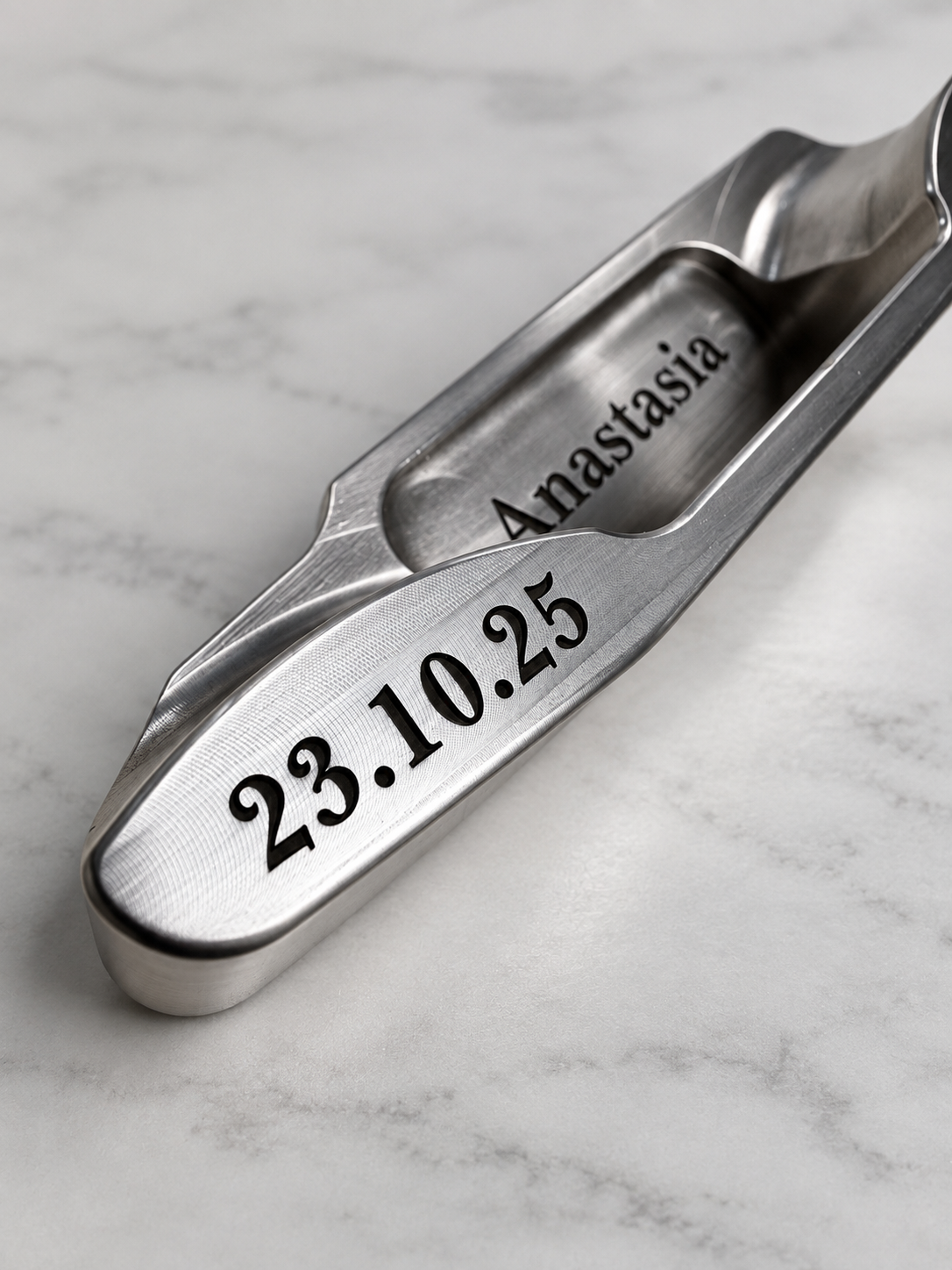 Custom name and date engraving on the sole of a stainless steel putter